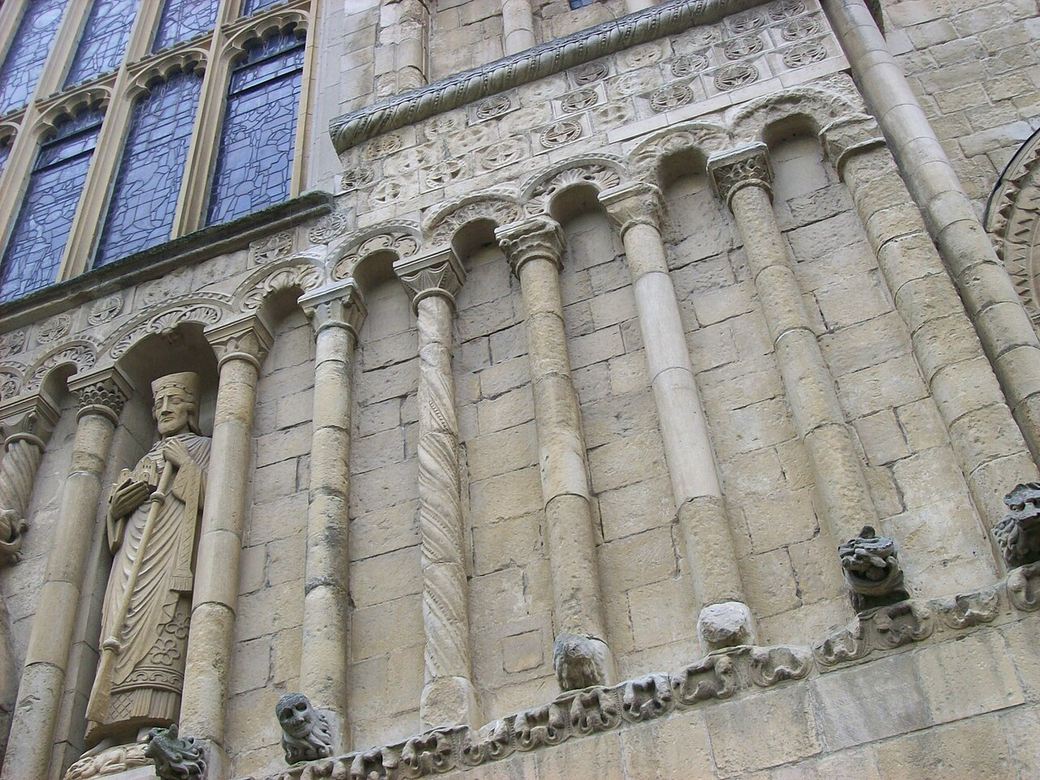 Romanesque blind arcading and a carved figure on the west front of Rochester Cathedral