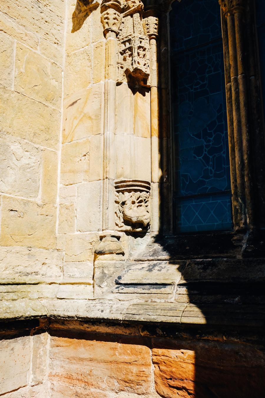 Weathered carved niches and a window on the outside wall of Rosslyn Chapel