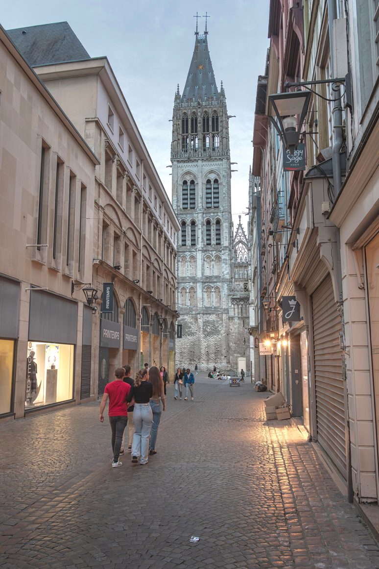 A street in old Rouen at dusk leading towards one of the tall towers of the cathedral
