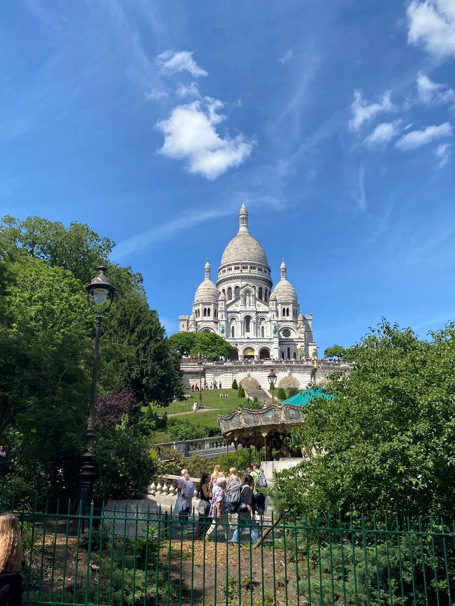 Sacré-Cœur at the top of Montmartre seen from the gardens and carousel below