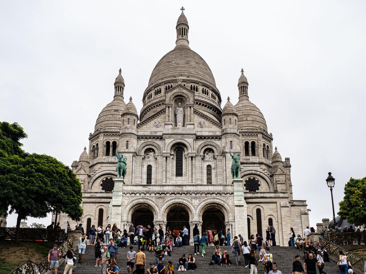 Crowds of visitors on the steps in front of Sacré-Cœur on a grey day