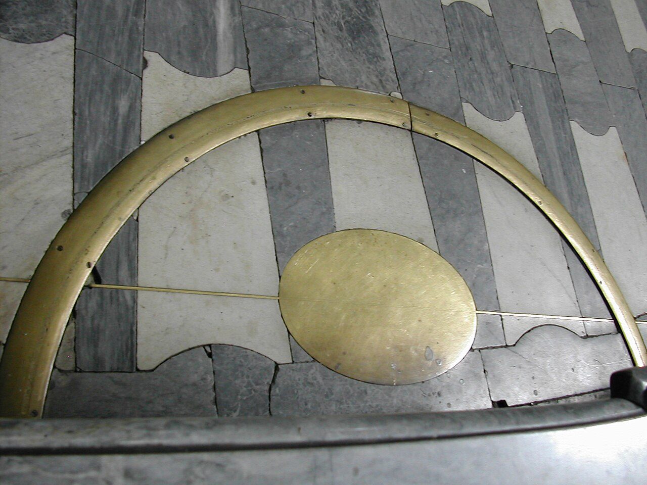 The brass line of the gnomon crossing the marble floor of Saint-Sulpice, with an oval brass plate