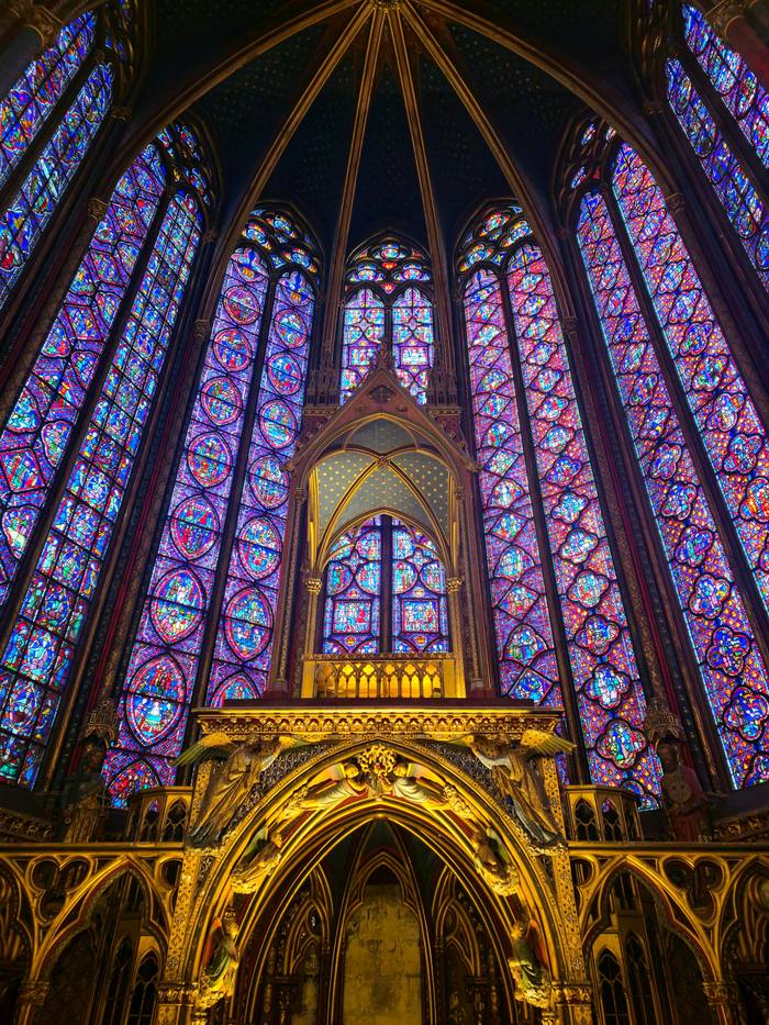 The apse of the Sainte-Chapelle with the gilded tribune of the relics beneath tall windows