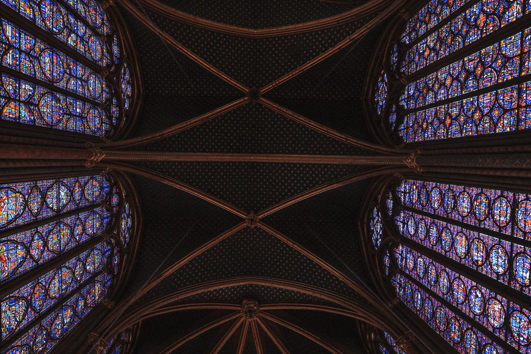Looking straight up at the painted vault of the Sainte-Chapelle between walls of glass