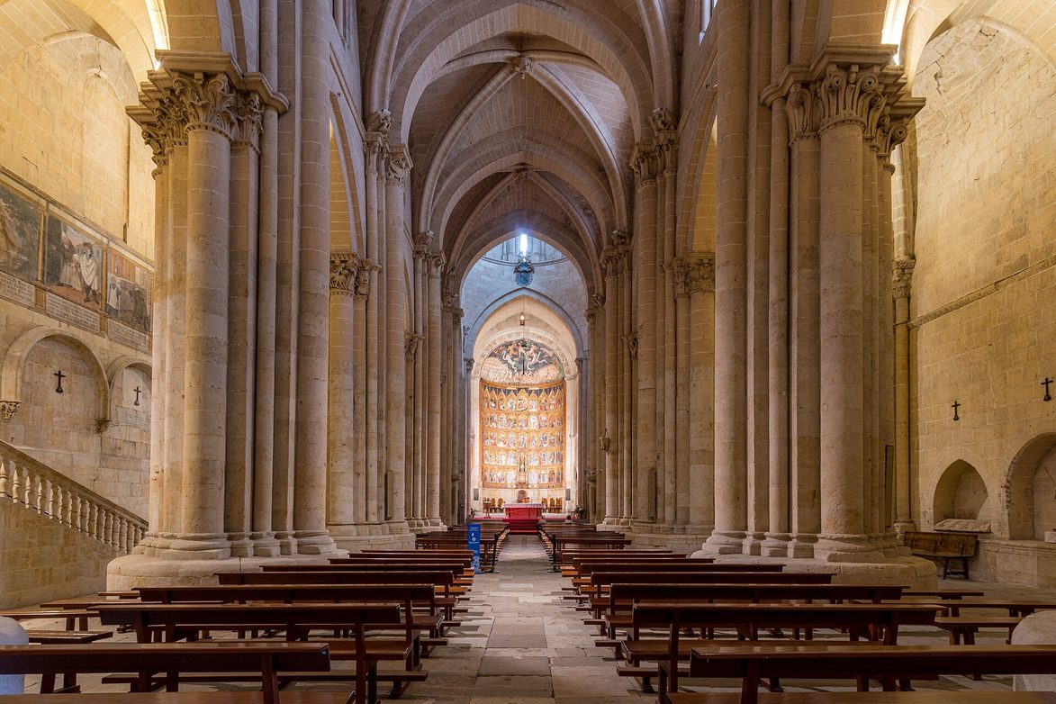 The Romanesque nave of the Old Cathedral of Salamanca leading to a golden altarpiece of many painted panels