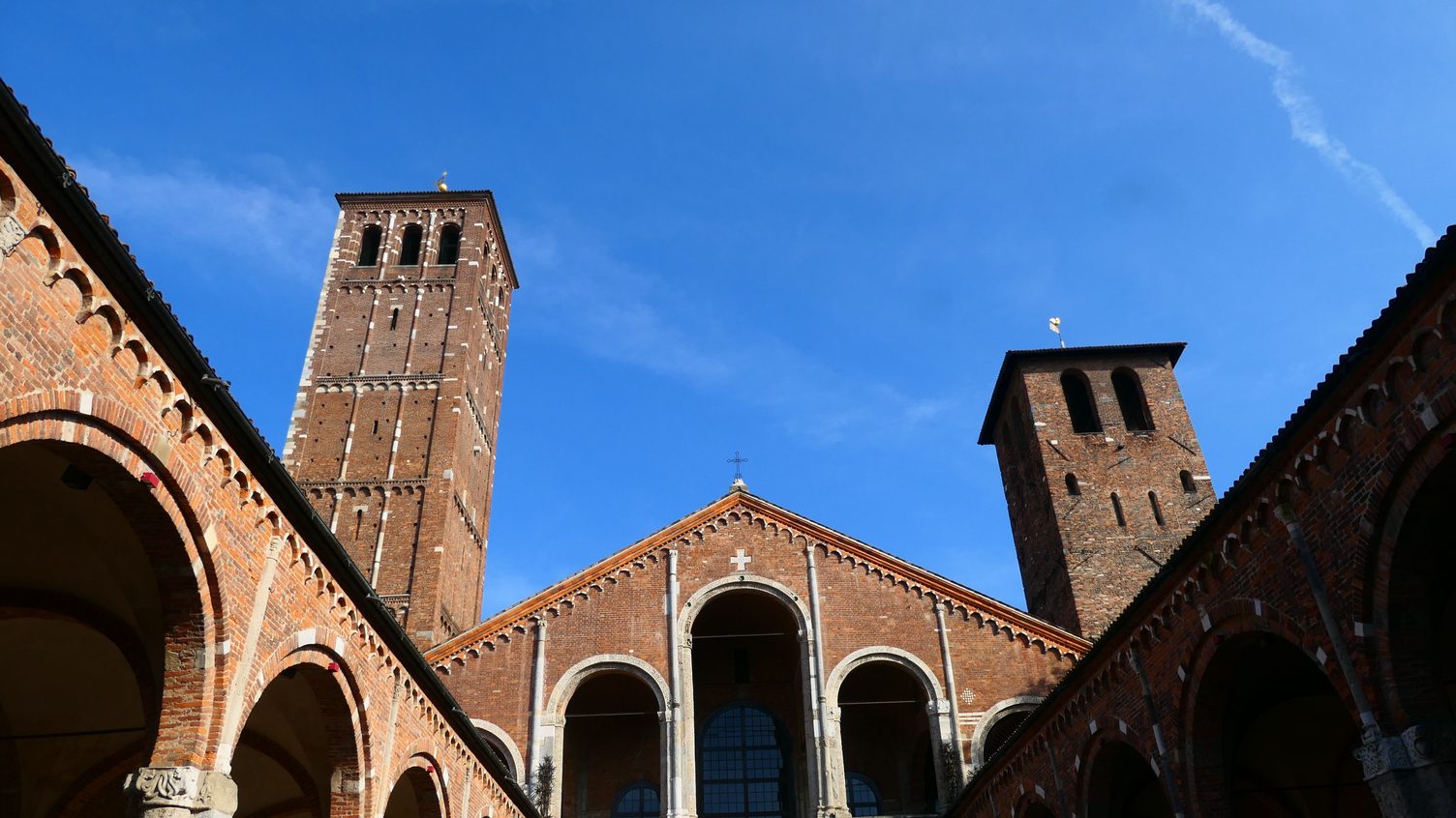 The arcaded brick atrium of Sant'Ambrogio, with the church front and its two bell towers at the far end