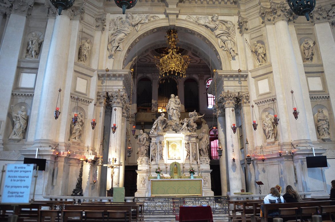The white and grey interior of Santa Maria della Salute, looking towards the high altar and its sculpture