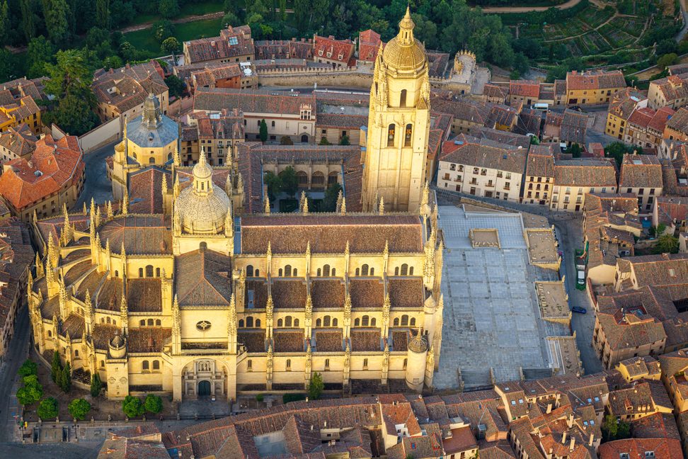 Aerial view of Segovia Cathedral beside the Plaza Mayor, surrounded by the roofs of the old town