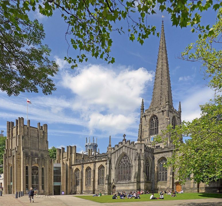 Sheffield Cathedral in the city centre, its medieval tower and spire beside the newer extensions, with trees in the cathedral forecourt