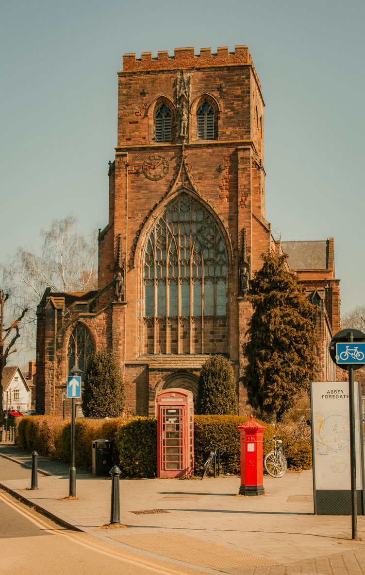 The west front of Shrewsbury Abbey seen from Abbey Foregate, with a red telephone box and post box in front