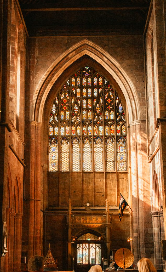 The great west window of Shrewsbury Abbey seen from inside, filled with stained glass above the west door
