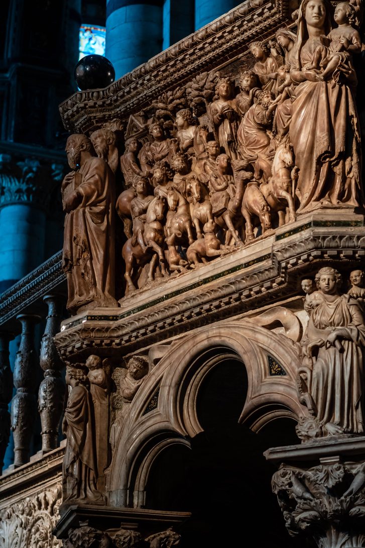 Carved marble reliefs crowded with figures on Nicola Pisano's pulpit in Siena Cathedral