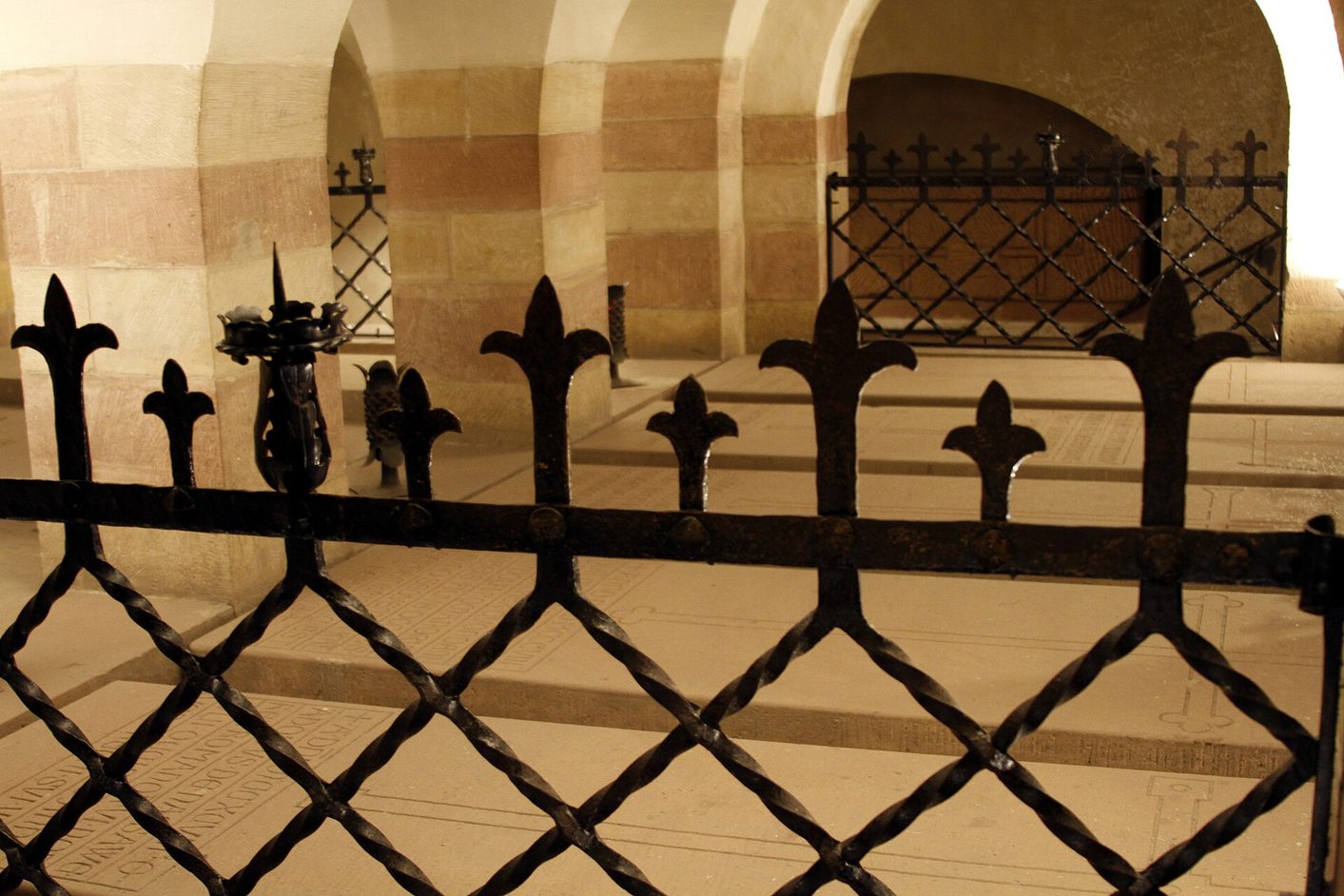 Stone tombs of the emperors behind an iron grille in the burial vault of Speyer Cathedral