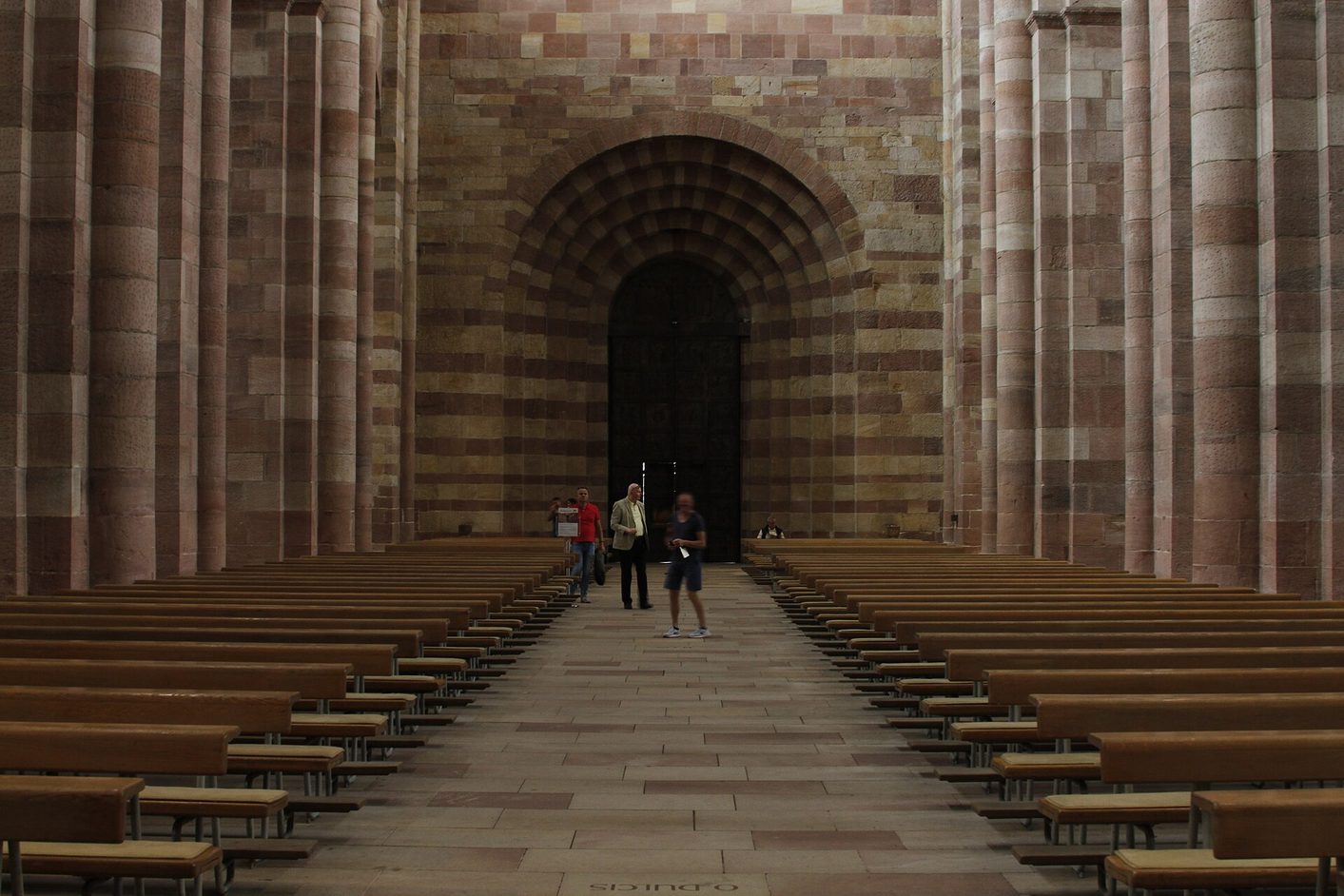 The long, plain Romanesque nave of Speyer Cathedral, with massive piers of red and yellow sandstone