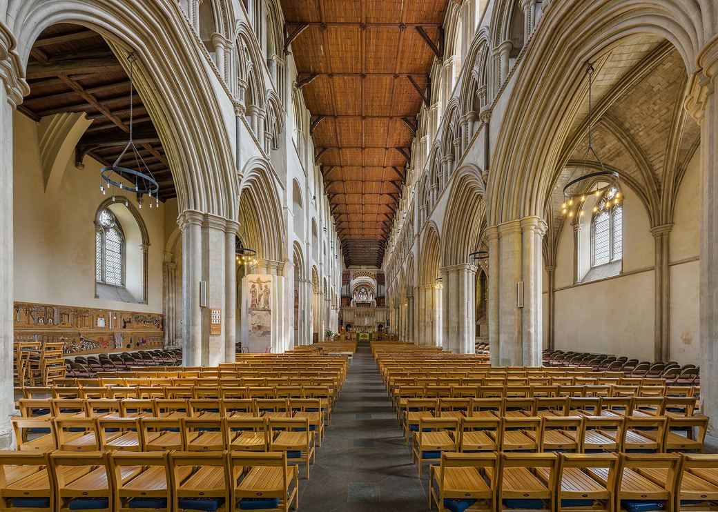 The very long nave of St Albans Cathedral with Norman arches on one side and Gothic arches on the other