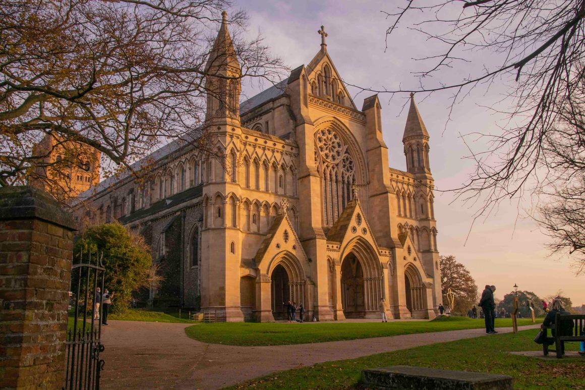 The north transept of St Albans Cathedral with its great rose window, lit by a warm sunset