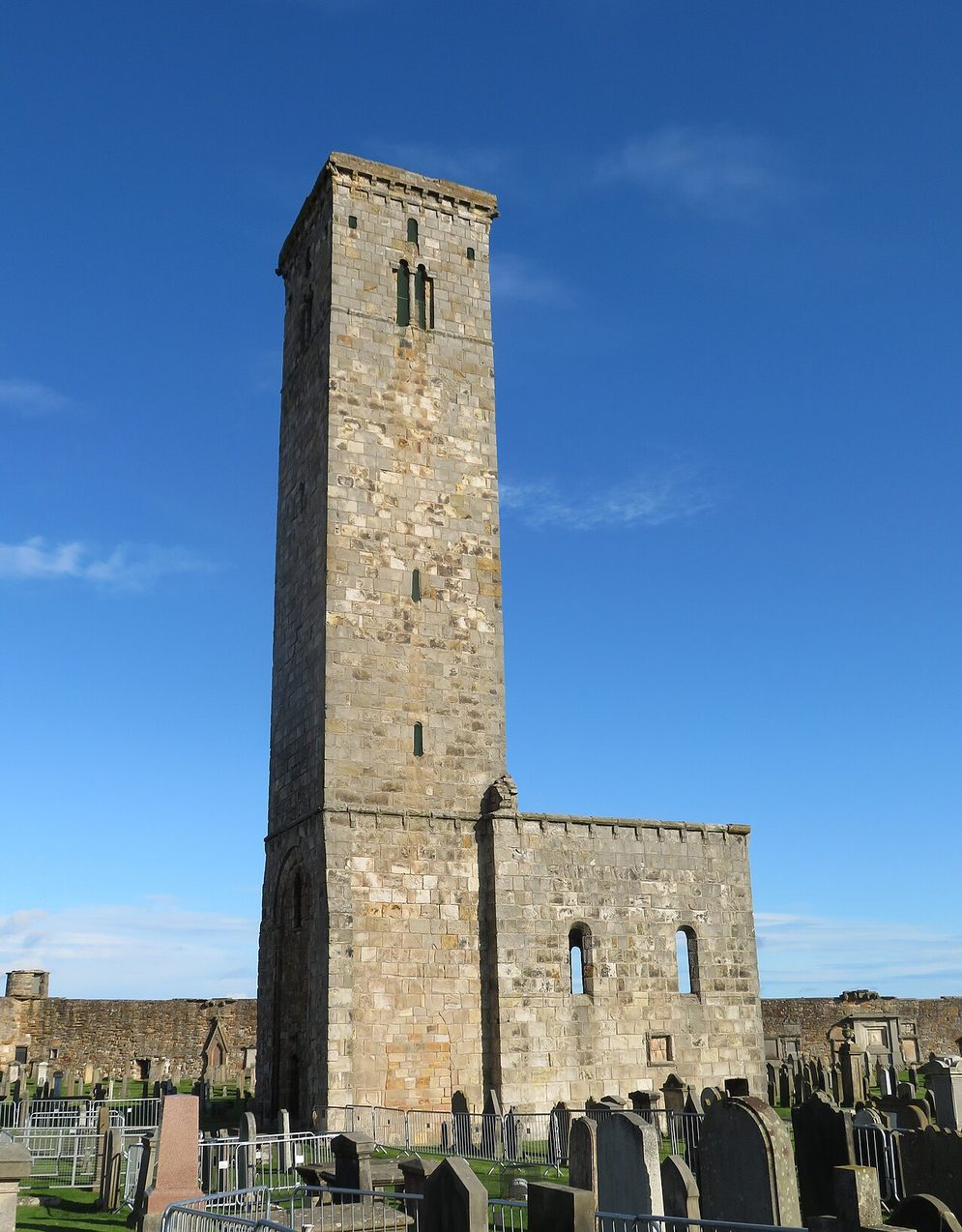 St Rule's Tower, a tall plain square Romanesque tower with a small church attached, among gravestones