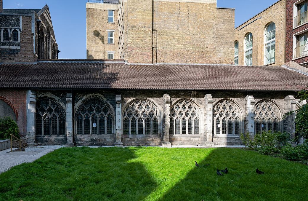 A restored section of the cloister walk at St Bartholomew the Great beside a lawn