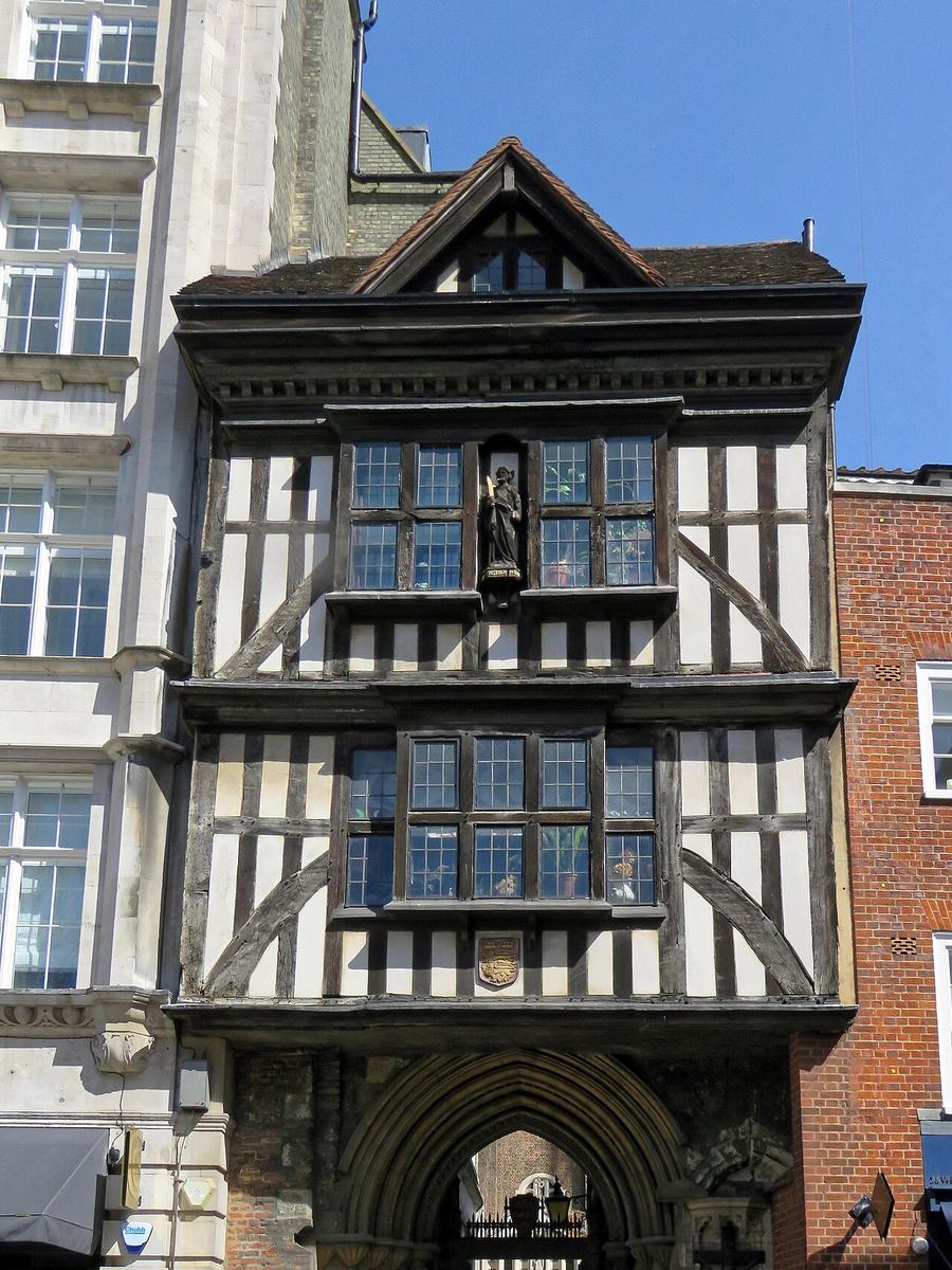 The Tudor half-timbered gatehouse of St Bartholomew the Great above a stone archway on West Smithfield