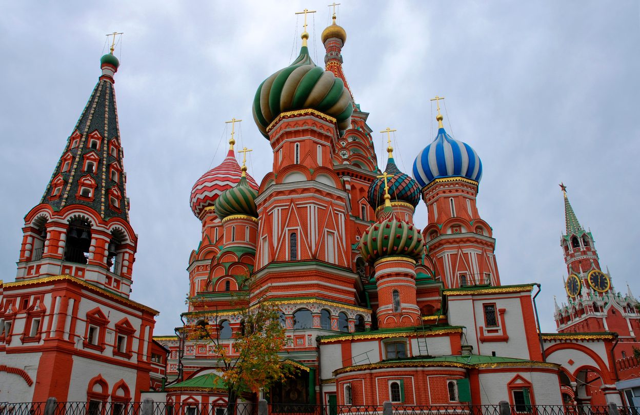 The striped, spiralled and faceted onion domes of St Basil's Cathedral in bright colours against a blue sky