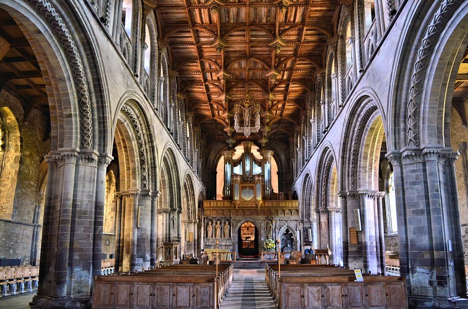 The Norman nave of St Davids Cathedral, with round arches and a carved wooden ceiling of Irish oak