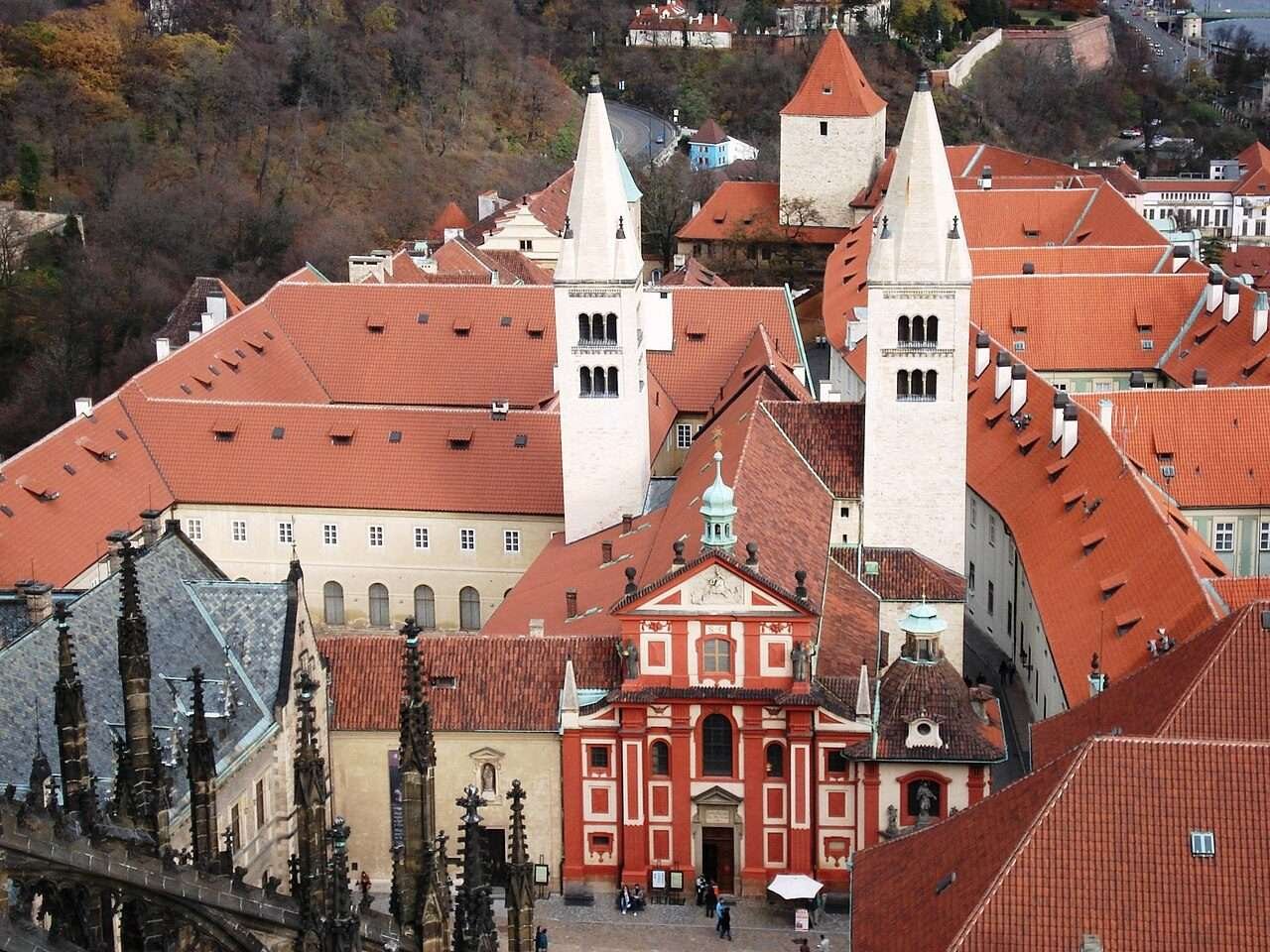 The red Baroque twin towers of the Basilica of St George rising above the rooftops of Prague Castle
