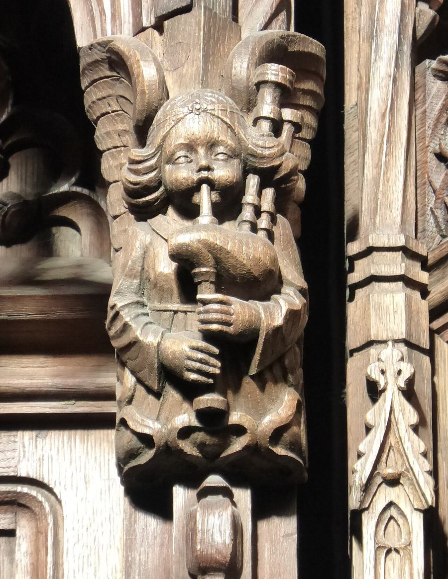 A carved wooden angel playing the bagpipes in the Thistle Chapel