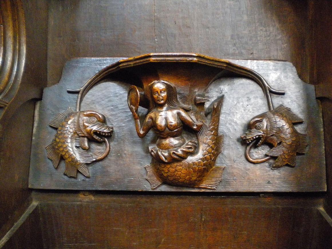 A medieval carved wooden misericord at St Laurence's, Ludlow, showing a mermaid between two fish-like beasts