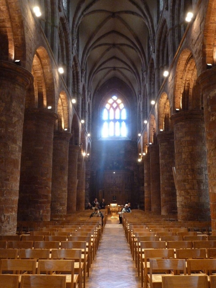 The tall, narrow nave of St Magnus Cathedral, with massive round Romanesque pillars and arches, looking west