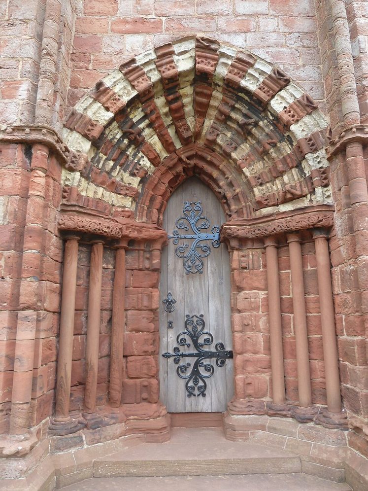 A doorway in the west front of St Magnus Cathedral, with arches of alternating red and yellow stone
