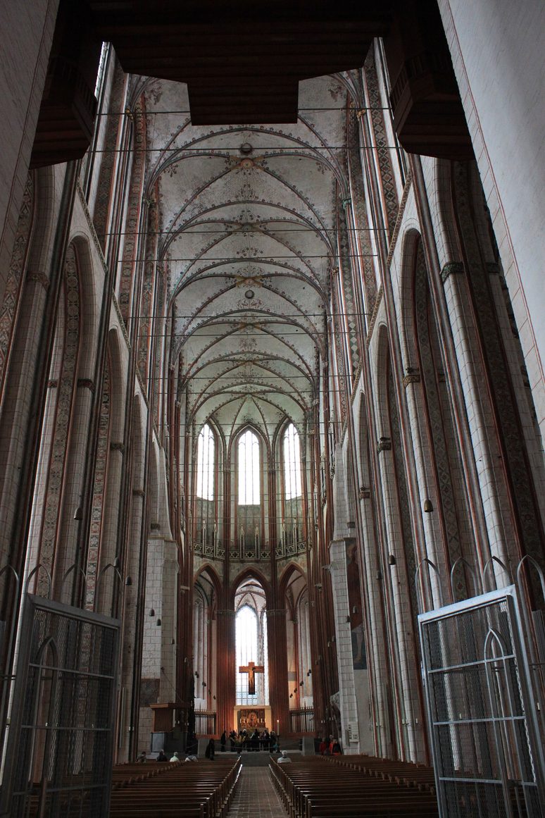The tall whitewashed Gothic nave of St Mary's Church, Lübeck, looking east between brick piers towards the choir