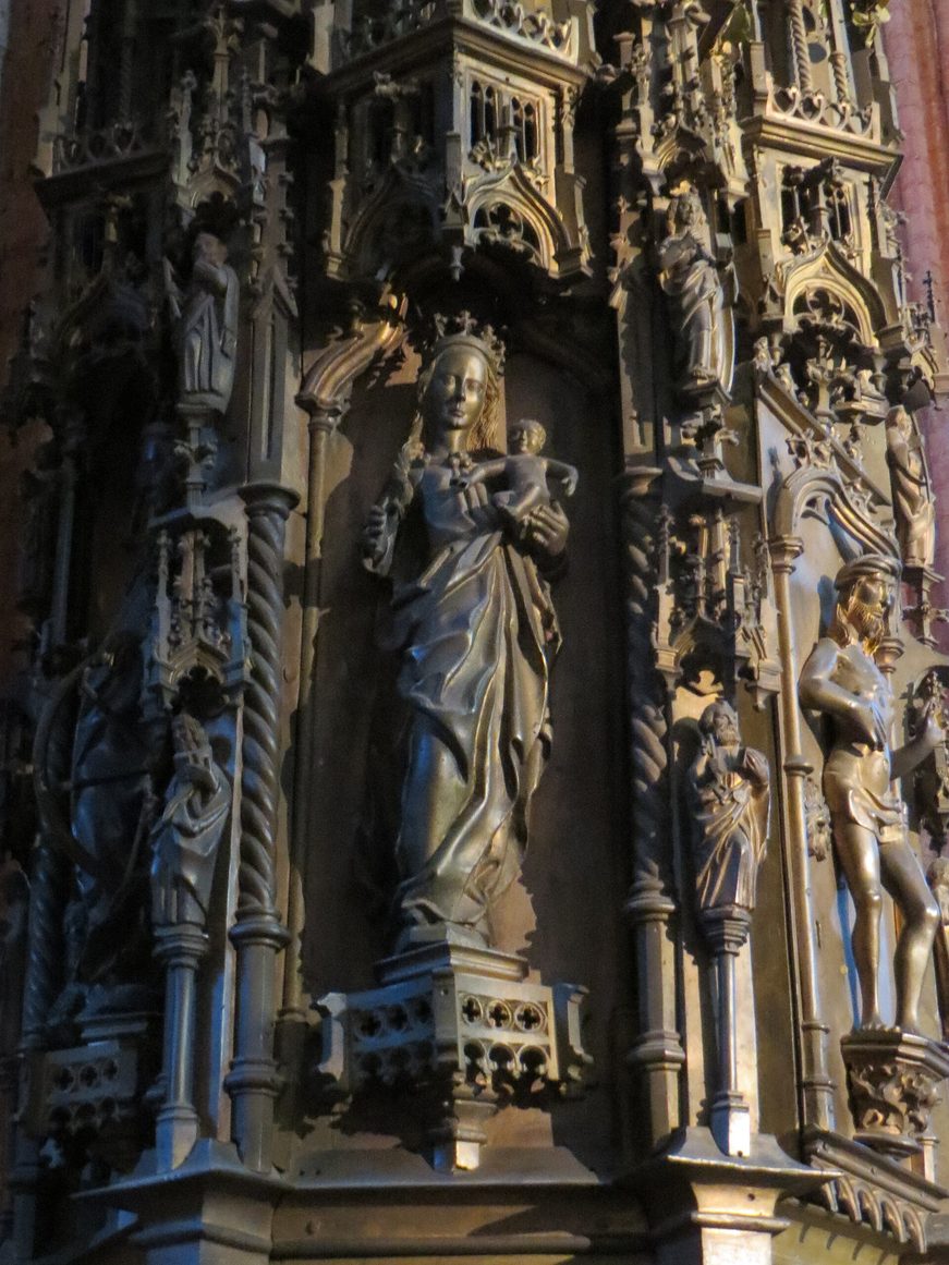 Detail of the tall late-Gothic sacrament house in St Mary's, Lübeck, with a figure of the Virgin among bronze-coloured tracery