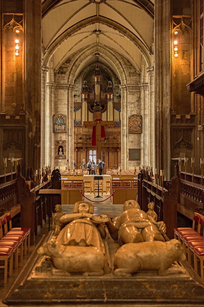 The effigies of Thomas Beauchamp, Earl of Warwick, and his wife Katherine holding hands on their tomb in the chancel of St Mary's, Warwick, looking west to the nave