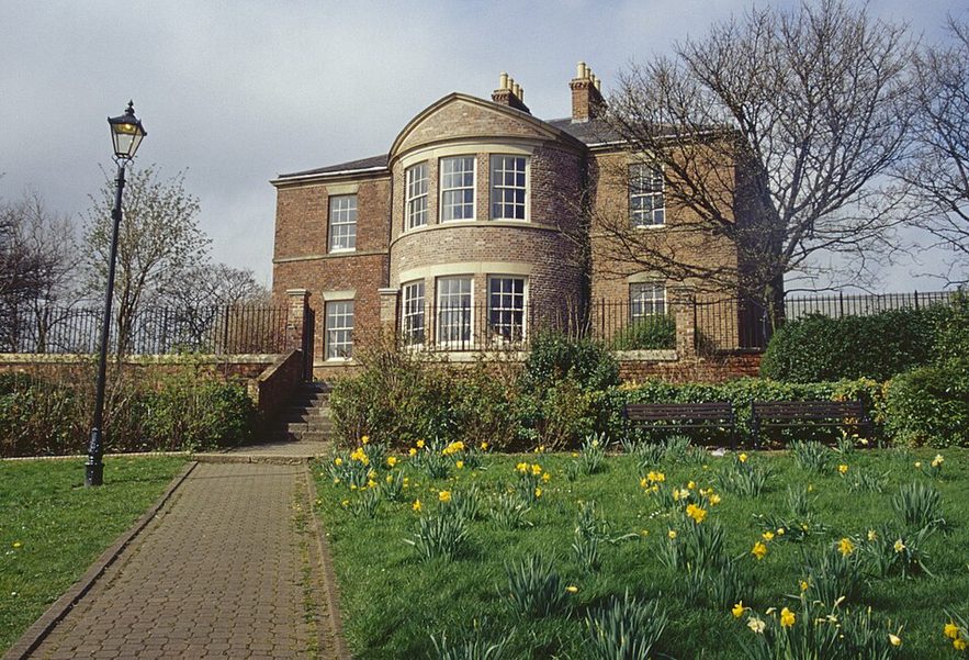 Jarrow Hall, a Georgian red-brick house with a bowed front, beside St Paul's Church