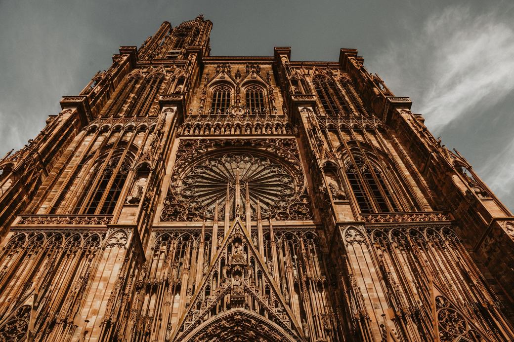 The west front of Strasbourg Cathedral in pink sandstone seen from below, with its great rose window