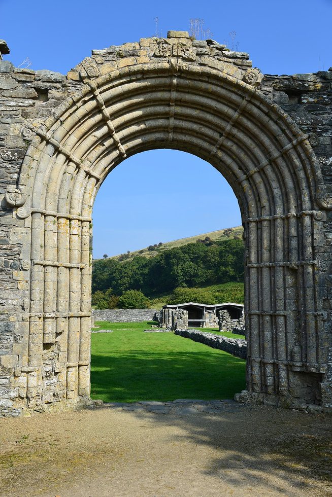 Close view of the Romanesque west doorway of Strata Florida Abbey, its roll mouldings bound by carved bands ending in spirals