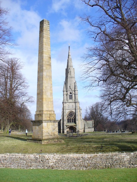 The stone obelisk in Studley Royal deer park with the spire of St Mary's Church beyond