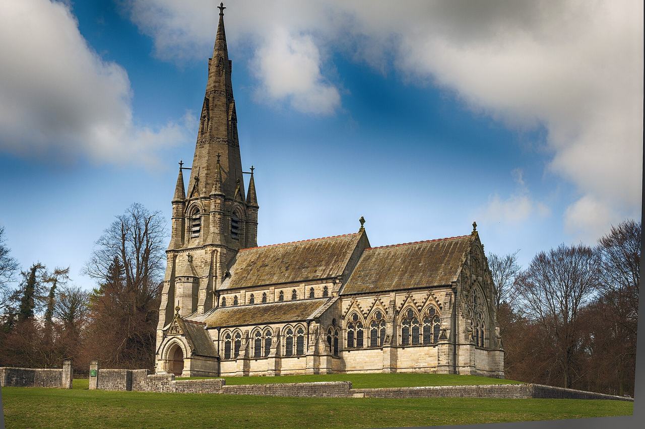 St Mary's Church at Studley Royal, a Victorian Gothic church with a tall spire, standing in open parkland