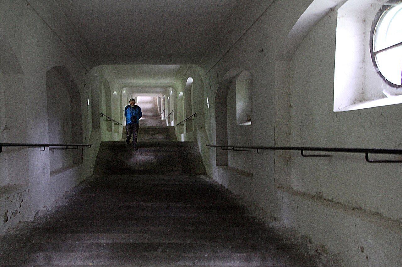 Inside the covered stairway to Svatá Hora, a long white vaulted passage of steps