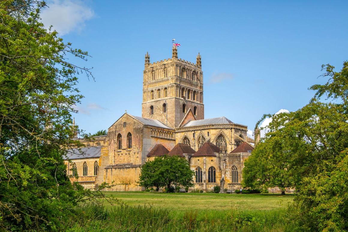 Tewkesbury Abbey and its massive Norman central tower seen across a meadow