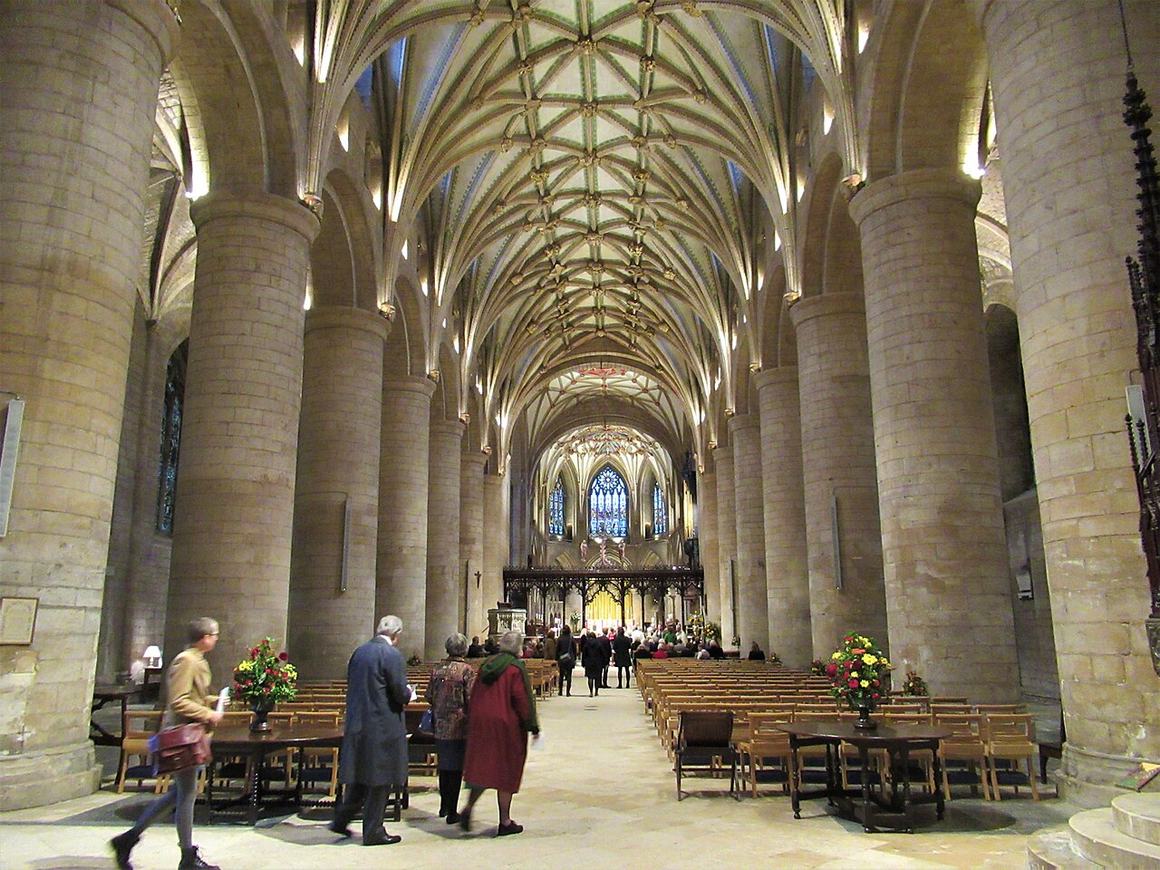 The nave of Tewkesbury Abbey with massive round Norman pillars under a ribbed vault