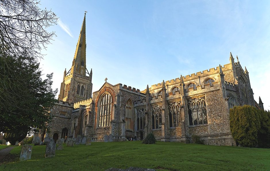 Thaxted parish church, Essex, seen from the south-east across the churchyard, with its tall spire and battlemented aisles