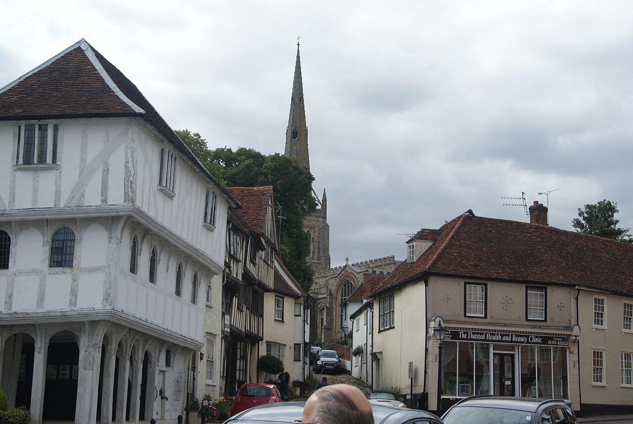 The spire of Thaxted church rising behind timber-framed houses in Watling Street, Thaxted