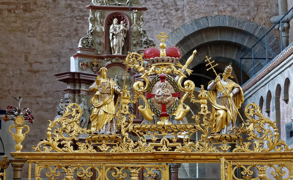 An ornate gilded wrought-iron screen and gate in Trier Cathedral
