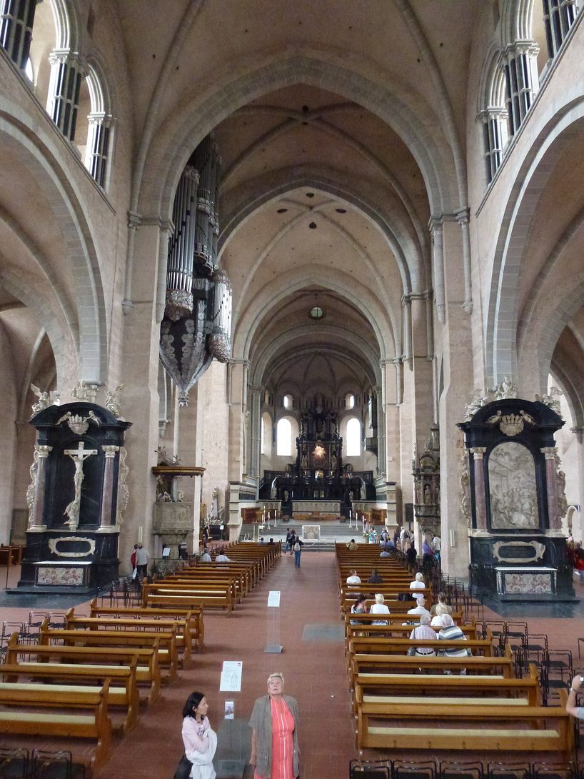 The nave of Trier Cathedral looking east, with plain Romanesque arches and white vaults leading to the raised Romanesque east choir