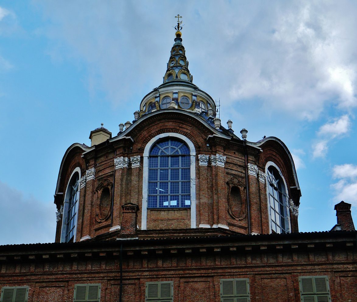 The stepped brick drum and spire of the Chapel of the Holy Shroud rising behind Turin Cathedral