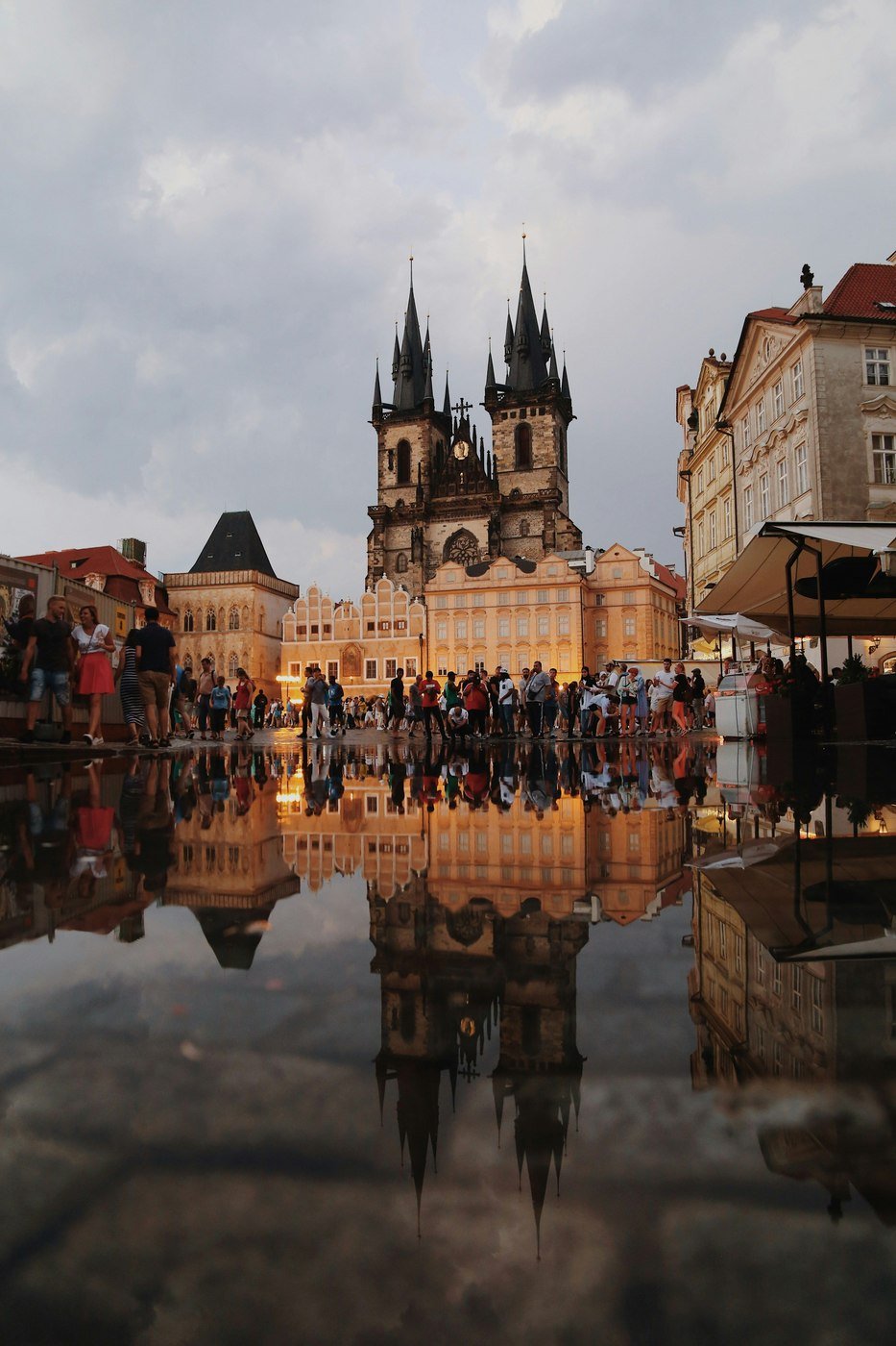 The towers of the Tyn church reflected in wet cobbles on Old Town Square, Prague