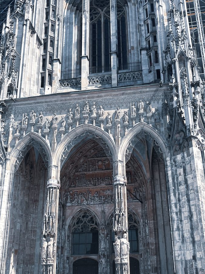 The arches and carved tracery of the west porch of Ulm Minster seen from below