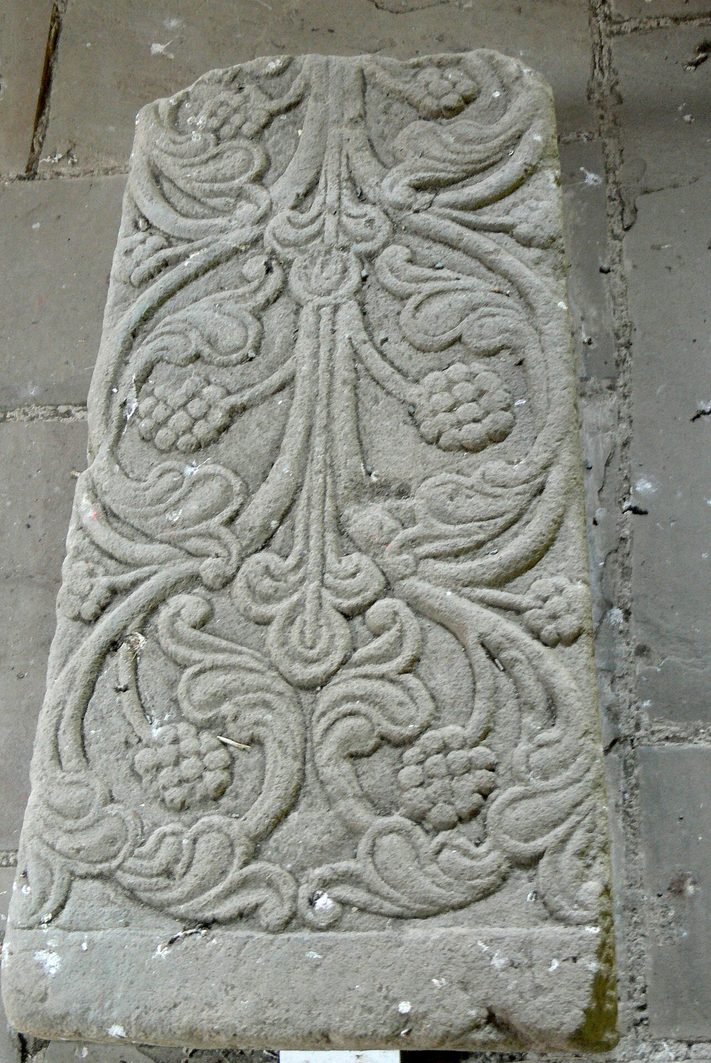 A medieval grave slab at Valle Crucis Abbey carved with a flowering cross and scrolling foliage
