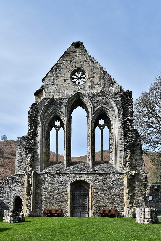 The west front of Valle Crucis Abbey with its doorway, three tall windows and the rose window above